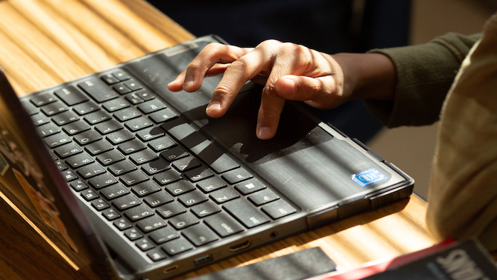 Person uses touchpad on a laptop computer.