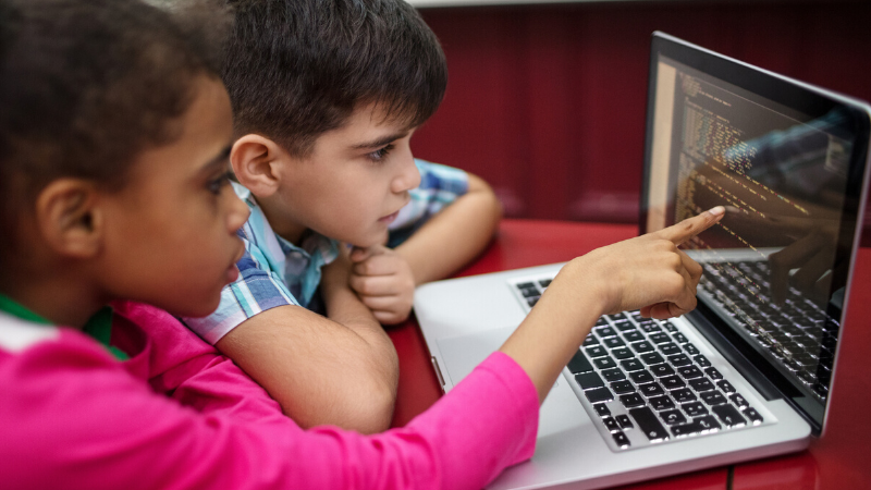 two elementary students learning to code