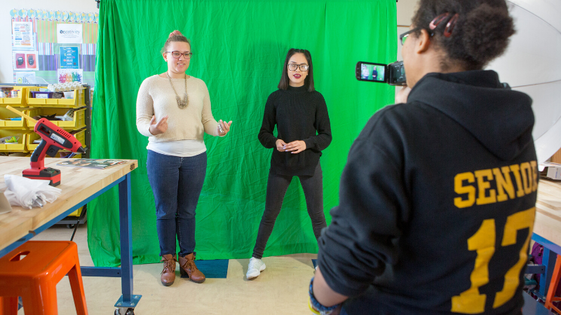 students filming in front of a green screen