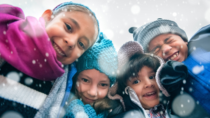 Kids in winter hats huddling together Kids in winter hats huddling together