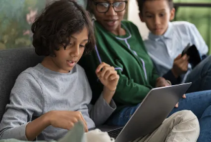 Kids and teacher sitting against a wall