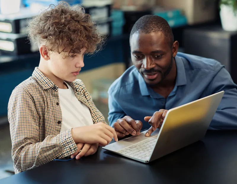 Photo of a teacher and a student learning about AI