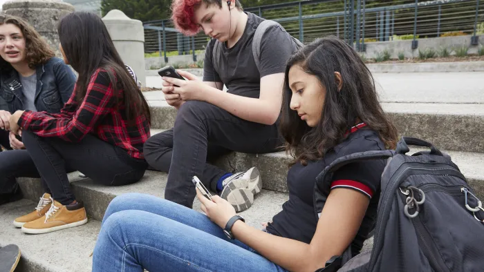 Students outside of class on phones.