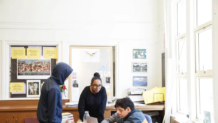 Four students in a classroom discussing something
