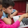 two elementary students learning to code